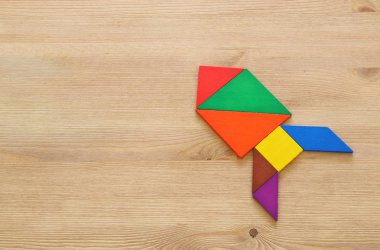 tangram bulmacanın mavi pastel ahşap arka plan üzerinde yapılan roket.