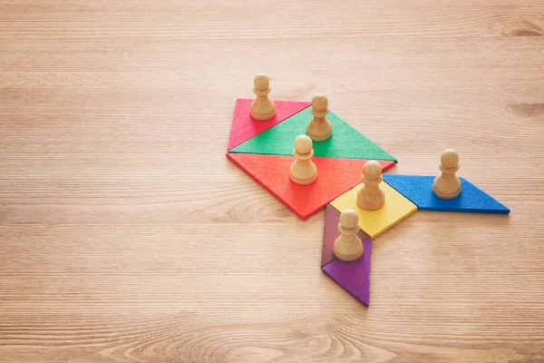 Bild von Tangram-Puzzlebausteinen mit Schachfiguren über Holztisch, Personalwesen und Managementkonzept. — Stockfoto