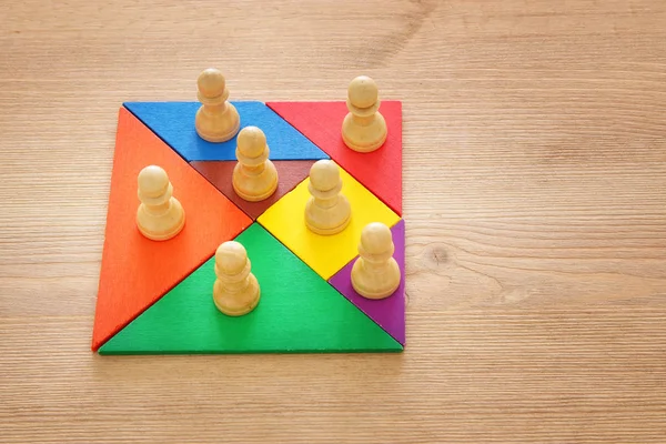 Bild von Tangram-Puzzlebausteinen mit Schachfiguren über Holztisch, Personalwesen und Managementkonzept. — Stockfoto