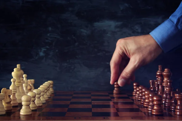 Image d'un homme d'affaires qui déplace une figure d'échecs sur un échiquier. Entreprise, concurrence, stratégie, leadership et concept de réussite . — Photo