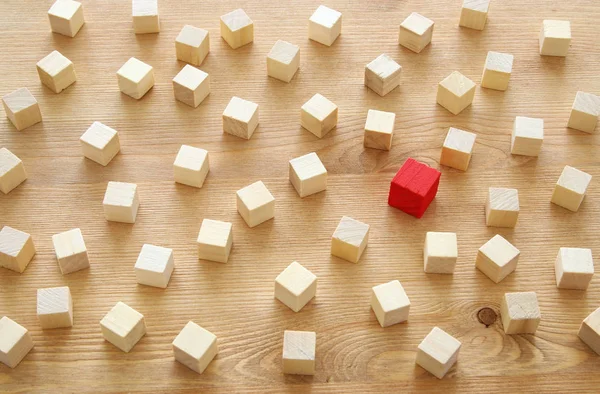 Egy másik piros kocka blokk fadarabot között. Egyéniség, a vezetés és az egyediség koncepció. — Stock Fotó