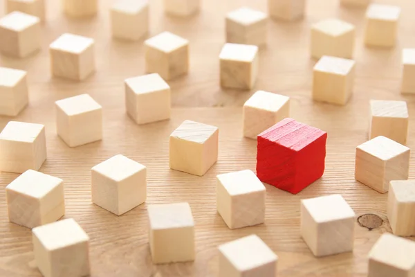 Egy másik piros kocka blokk fadarabot között. Egyéniség, a vezetés és az egyediség koncepció. — Stock Fotó