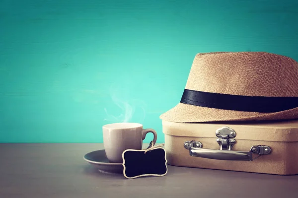 Image of cup of coffee, old box and male fedora hat over wooden table. Father's day concept