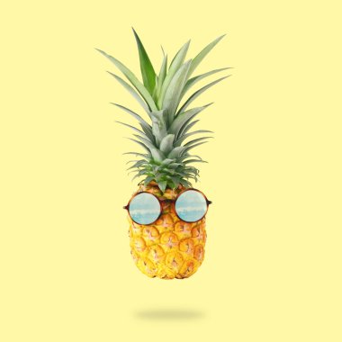 en az kavramı. Pastel sarı zemin üzerinde güneş gözlüklü şirin ve komik ananas