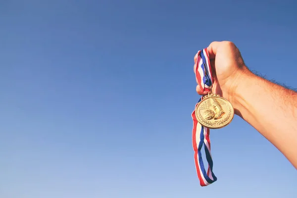 Man Hand Opgeheven Met Gouden Medaille Tegen Lucht Award Overwinningsconcept — Stockfoto