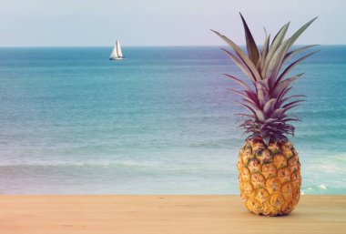 Ahşap masa üzerinde ananas. Plaj ve tropikal Tema