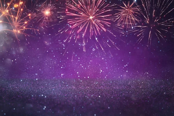 abstract gold and purple glitter background with fireworks. christmas eve, 4th of july holiday concept