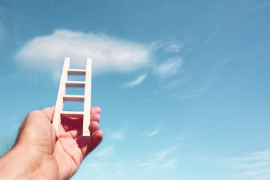 bir merdiven gökyüzüne karşı tutan adam el görüntüsü. Eğitim ve başarı kavramı