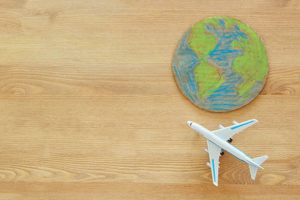 Uçak ve dünya dünya üzerinde ahşap arka plan görüntüsünü üstten görünüm.