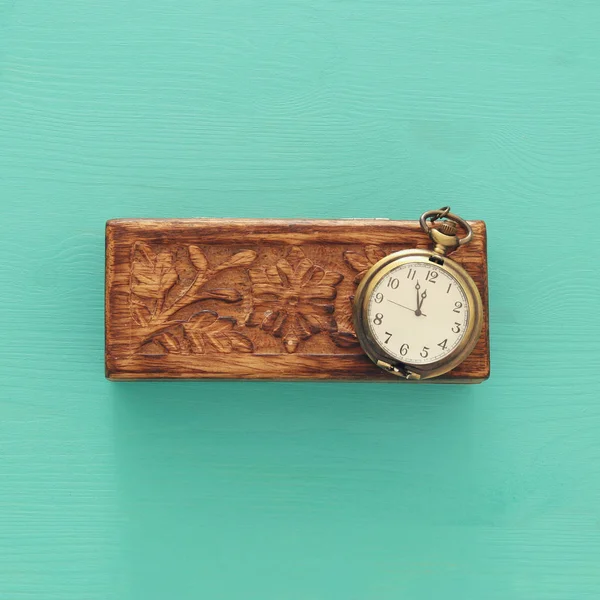 Vista superior de la vieja caja de madera y reloj de bolsillo vintage sobre fondo azul . — Foto de Stock