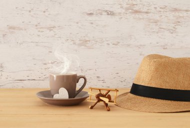 Erkek fedora şapka, sıcak kahve ya da çay ve uçak oyuncak ahşap masa görüntüsü. Babalar günü kavramı