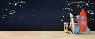 Geri okul kavramı. roket ve önünde sınıf yazı tahtası kalemleri