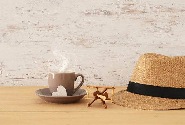 Erkek fedora şapka, sıcak kahve ya da çay ve uçak oyuncak ahşap masa görüntüsü. Babalar günü kavramı