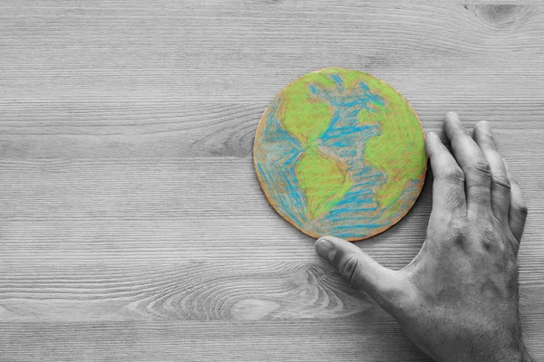 ahşap masa üzerinde dünya küre tutan adam el üstten görünüm görüntüsü. Seçmeli renk