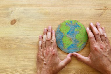 ahşap arka plan üzerinde dünya küre holding adam eller görüntüsünü üstten görünüm