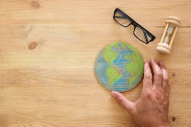 ahşap masa üzerinde dünya küre holding adam eller görüntüsünü üstten görünüm