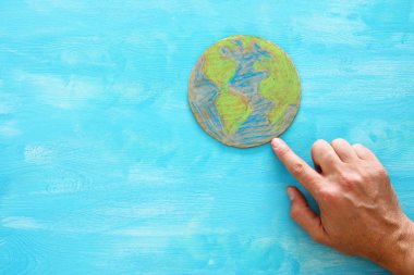 Dünya küre mavi ahşap arka plan üzerinde gösteren bir adam el görüntüsünü üstten görünüm