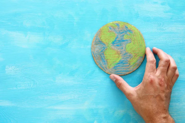 Dünya küre mavi ahşap arka plan üzerinde tutan adam el görüntüsünü üstten görünüm