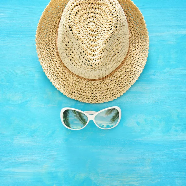 Tatil ve yaz görüntü ile fedora plaj şapka ve güneş gözlüğü mavi ahşap arka plan üzerinde