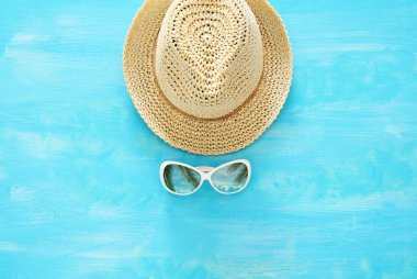Tatil ve yaz görüntü ile fedora plaj şapka ve güneş gözlüğü mavi ahşap arka plan üzerinde