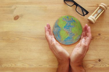 ahşap masa üzerinde dünya küre holding adam eller görüntüsünü üstten görünüm