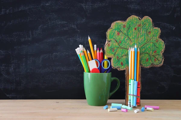 Back to school concept. tree of knowledge and pencils in front of classroom blackboard