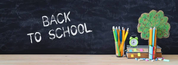 Back to school concept. tree of knowledge and pencils in front of classroom blackboard