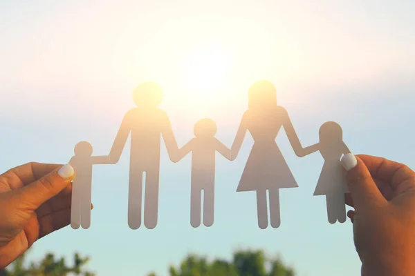 Image of happy family concept.woman holding paper cut people against sky during sunset. — Stock Photo, Image