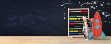 Geri okul kavramı. roket ve önünde sınıf yazı tahtası kalemleri