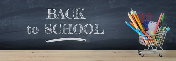 Banner of Shopping cart with school supply in front of blackboard. Back to school concept