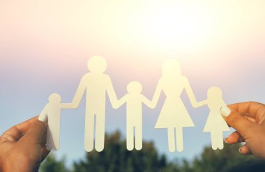 mutlu aile concept.woman kağıt tutan görüntüsünü insanlar karşı gökyüzü günbatımı sırasında kesim