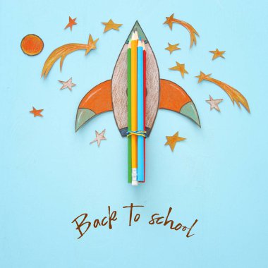 Geri okul kavramı. roket, alan öğeler şekiller kesilmiş kağıt ve boyalı ahşap mavi arka plan üzerinde