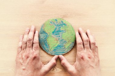ahşap masa üzerinde dünya küre holding adam eller görüntüsünü üstten görünüm