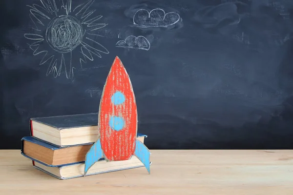 戻る学校バナー 教室の黒板の前に書籍の横に段ボール ロケットを塗装 — ストック写真