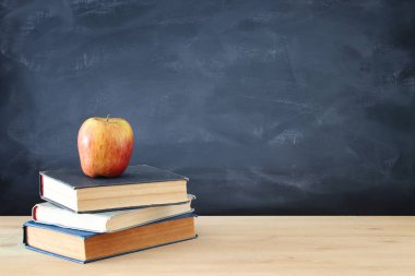 geri okul kavramı. yazı tahtası önünde ahşap Resepsiyon üzerinde kitap yığını