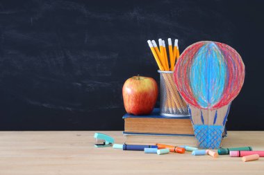 Geri okul kavramı. sıcak hava balon ve önünde sınıf yazı tahtası kalemleri