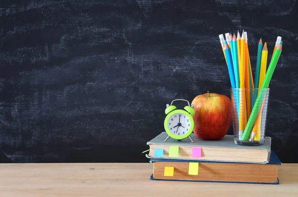 学校のコンセプトです 本と黒板の前に木製の机の上の鉛筆のスタック — ストック写真