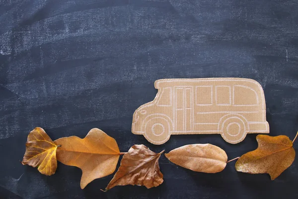 回到学校的概念 顶部视图图像纸板校车在干燥的叶子和教室黑板背景 — 图库照片