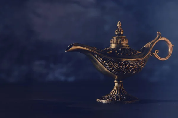 Image of magical mysterious aladdin lamp over black background. Lamp of wishes