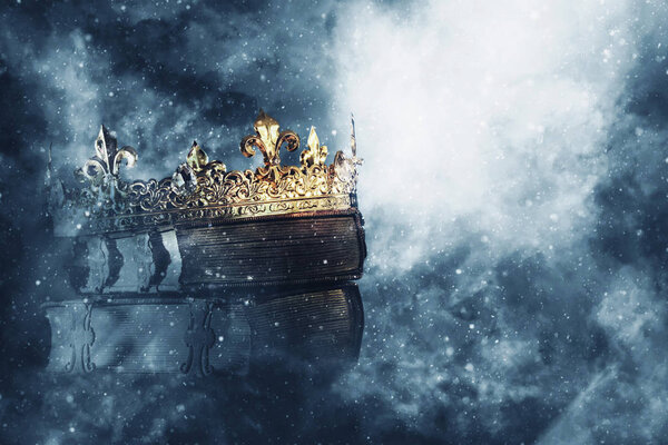 загадочное волшебное изображение старой короны и книга на готическом черном фоне. Концепция средневековья
