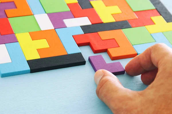 Man Hand Met Een Vierkante Tangram Puzzel Houten Tafel — Stockfoto