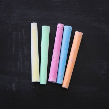 Blackboard arka plan üzerinde renkli tebeşirler üstten görünüm.