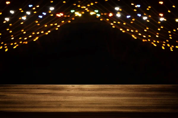 抽象的なぼやけた市黄金ガーランドの前に木製のテーブルのイメージ ライト背景 — ストック写真