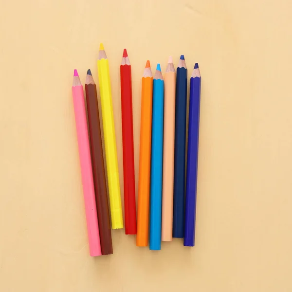 Top view of colorful pencils over wooden background. — Stock Photo, Image