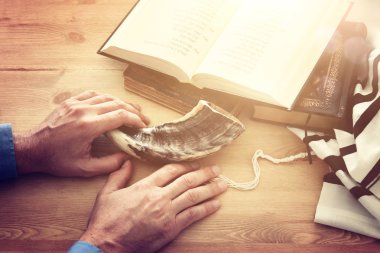 Jewish man hands next to Prayer book, praying, next to tallit. Jewish traditional symbols. Rosh hashanah (jewish New Year holiday), Shabbat and Yom kippur concept clipart