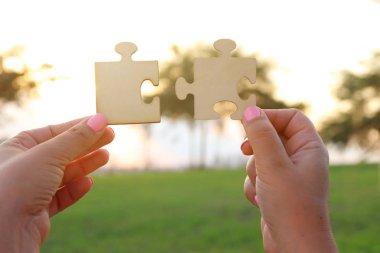 Bir kadın kavramı görüntüsünü bir bulmaca güneşin önünde iki adet tutan eller. Mercek parlaması ile günbatımı zamanı. yaratıcılık ve bağlantı fikir