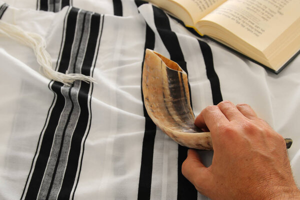 Jewish man hands next to Prayer book, praying, next to tallit. Jewish traditional symbols. Rosh hashanah (jewish New Year holiday), Shabbat and Yom kippur concept