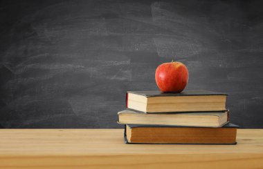 geri okul kavramı. yazı tahtası önünde ahşap Resepsiyon üzerinde kitap yığını