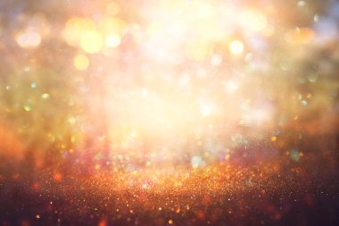 Ağaçlar arasında ışık patlaması ve parlak altın bokeh ışıklarının bulanık fotoğrafı.