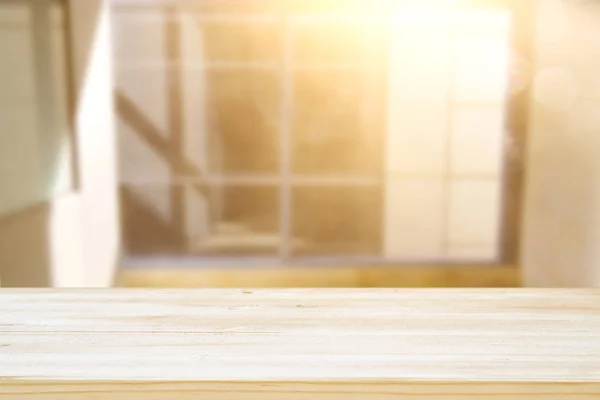 image of wooden table in front of abstract blurred window light background